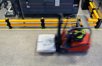 Forklift truck driving past A-SAFE safety barrier